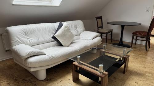 a living room with a white couch and a table at Ferienwohnung 3 beim Restaurant Rhodos in Heide