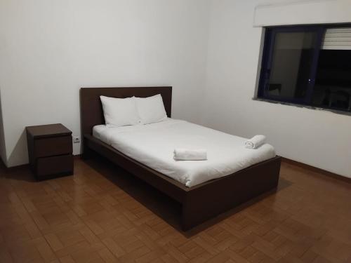 a small bed in a room with a window at Come Inn Costa da Caparica in Costa da Caparica