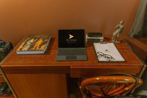 a desk with a laptop and books on it at Fly House Faro in FAO