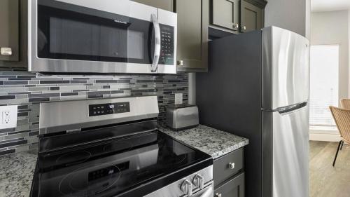 a kitchen with a microwave and a refrigerator at Landing at Residences at River Park West - Richmond in Richmond