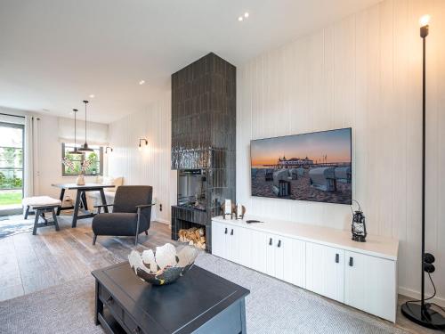 ein Wohnzimmer mit einem Fernseher an der Wand in der Unterkunft Reetidyll am Haff in Stolpe auf Usedom