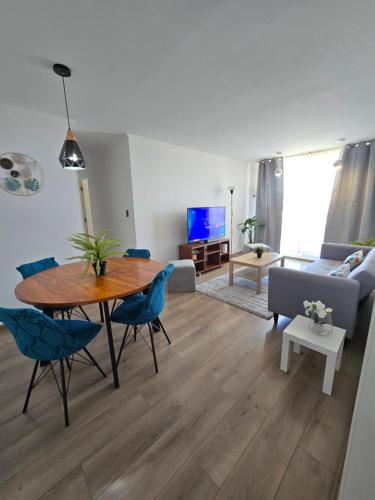 a living room with a table and blue chairs at Departamento Premium Full equipado in Rancagua