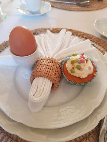 a plate with an egg and a cupcake and cookies at Auberge de La Chaloire in La Petite-Verrière