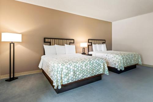 a hotel room with two beds and two lamps at HomeTowne Studios by Red Roof Ridgecrest in Ridgecrest