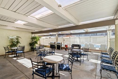 a patio with tables and chairs and a piano at HomeTowne Studios by Red Roof Ridgecrest in Ridgecrest