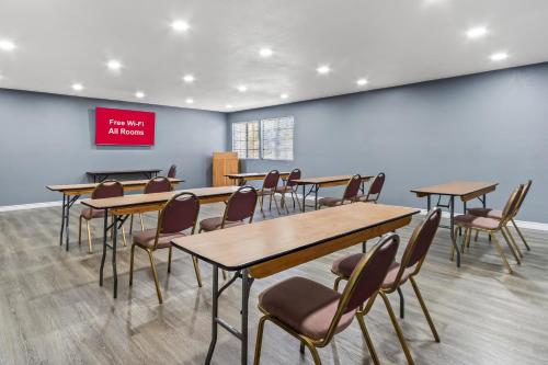 a classroom with tables and chairs and a red sign at HomeTowne Studios by Red Roof Ridgecrest in Ridgecrest