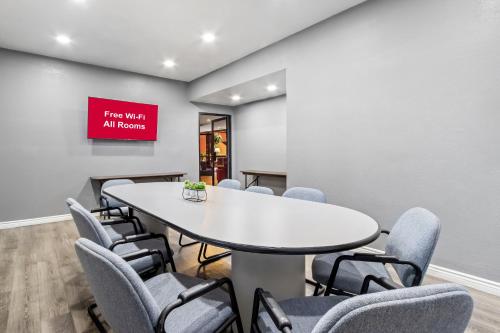 a conference room with a white table and chairs at HomeTowne Studios by Red Roof Ridgecrest in Ridgecrest