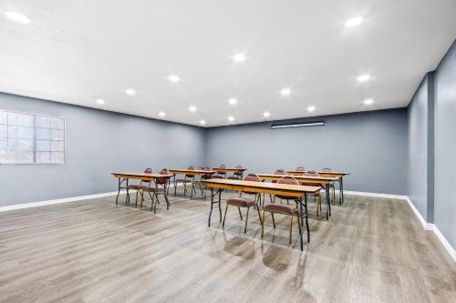 a group of tables and chairs in a room at HomeTowne Studios by Red Roof Ridgecrest in Ridgecrest