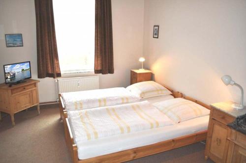 a bedroom with a large bed and a television at Hof Kröger Ferienwohnung Nr 04 in Travemünde