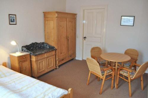 a bedroom with a bed and a table and chairs at Hof Kröger Ferienwohnung Nr 04 in Travemünde