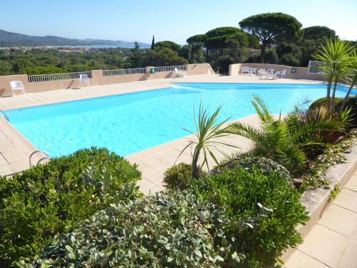 una grande piscina con alberi e piante di Ferienhaus mit Blick auf Grimaud (Fle) a Cogolin