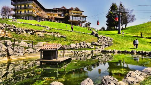 a man standing in front of a pond in front of a building at T'AMI Hotel Resort Spa in Selvino