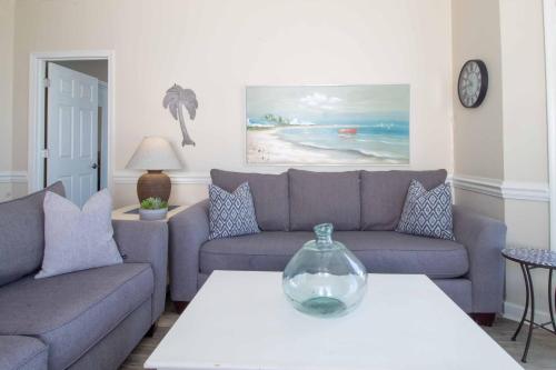 a living room with a couch and a vase on a table at Sand Castle in the Sky in Folly Beach