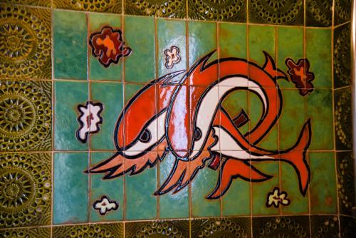 a painting of a fish on a tile wall at Jacuzzi Artistic Villa in Nea Makri in Nea Makri
