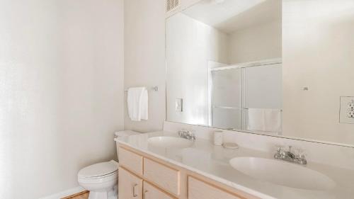 a white bathroom with two sinks and a toilet at Landing at Settlers Ranch - Pasadena in Houston