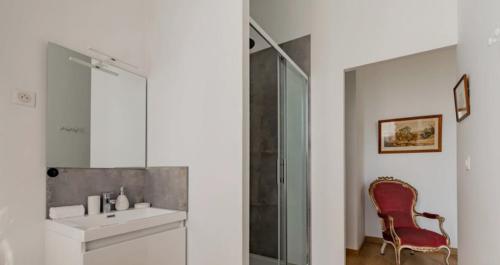 a bathroom with a sink and a mirror and a chair at Château Féger 5 suites in Camblanes-et-Meynac
