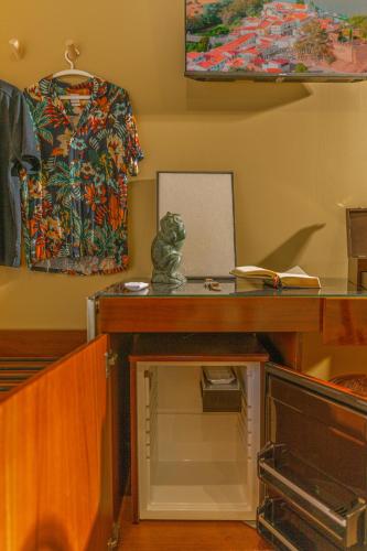 a desk with a glass top and a shirt on a wall at Fly House Faro in FAO