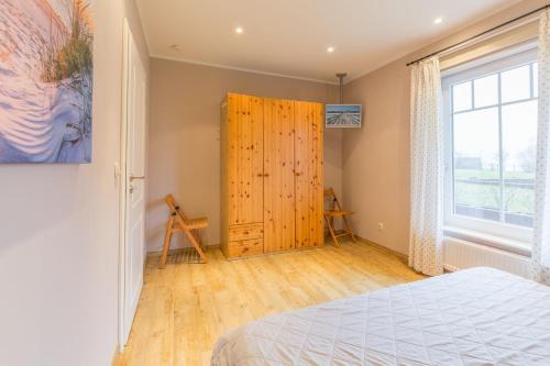 a bedroom with a bed and a wooden door at Ostseehaus Julia in Wohlenberg