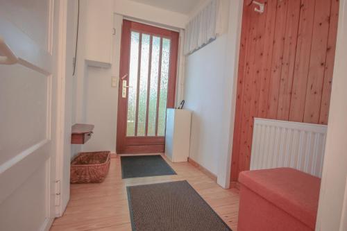a hallway with a door and a refrigerator in a room at Ferienwohnungen an der Marcusheide in Worpswede