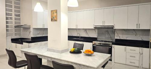 a kitchen with a table with a bowl of fruit on it at Ease Living Palem Kenari in Jatirarangan