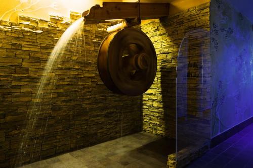 a bathroom with a water hose attached to a brick wall at T'AMI Hotel Resort Spa in Selvino