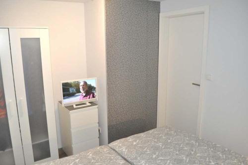 a bedroom with a tv on a dresser next to a bed at Haus Chalet 21 Ferienhaus in Haffkrug