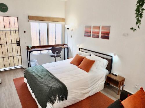 a bedroom with a bed and a desk in it at Sand Sun & Second - Charming Studio within Walking Distance to Beach in Long Beach