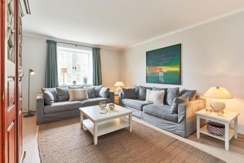 un soggiorno con due divani e un tavolo di Ferienhaus Silbermöwe 7d a List