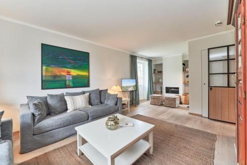 un soggiorno con un divano e un tavolo di Ferienhaus Silbermöwe 7d a List