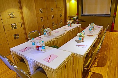 a row of tables in a room with red napkins at The Oriental Residency in Mumbai