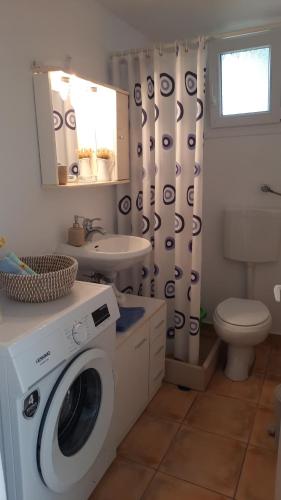 a bathroom with a washing machine and a sink at Monika's house in Chios
