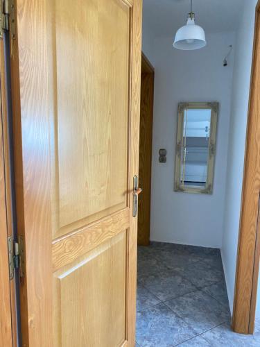 a wooden door in a room with a mirror at Porto Mare Apartment in Elafonisos