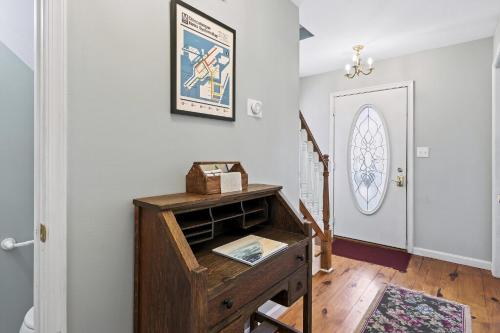 un corridoio con una scrivania in legno e una porta bianca di Victorian Cottage a Chincoteague