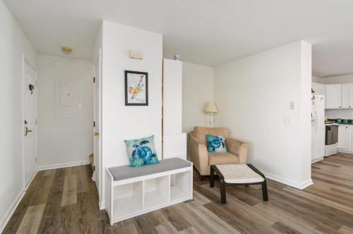 a white living room with a chair and a table at Lighthouse Overlook in Birch Town