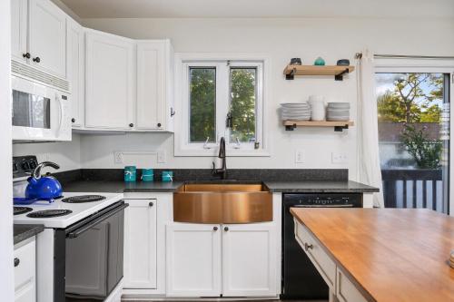 a kitchen with white cabinets and a stainless steel sink at Lighthouse Overlook in Birch Town