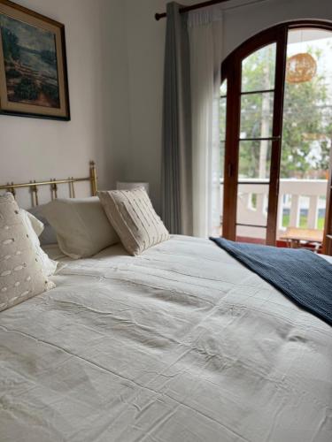 a white bed in a room with a window at Hotel Boutique La Residencia in Lima