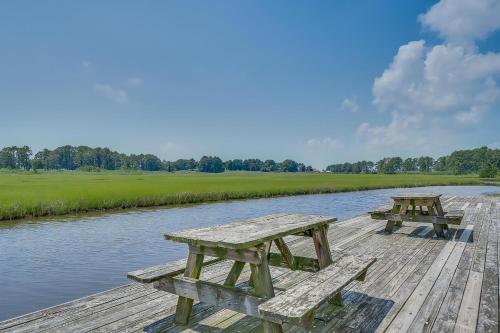 two picnic tables sitting on a wooden dock next to a river at Assateague Inn 107-A in Deep Hole