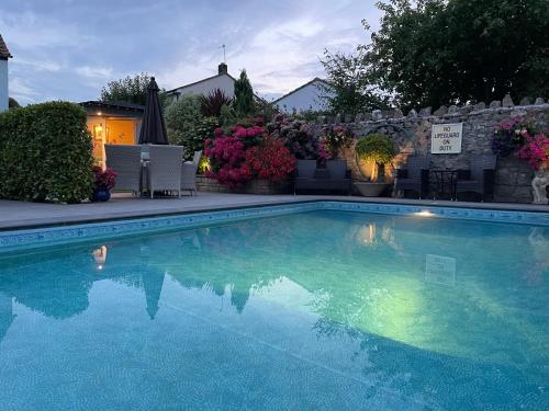 a swimming pool with blue water in a yard at Gordons in Cheddar