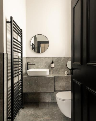 a bathroom with a sink and a toilet and a mirror at Moment Blythswood St in Glasgow