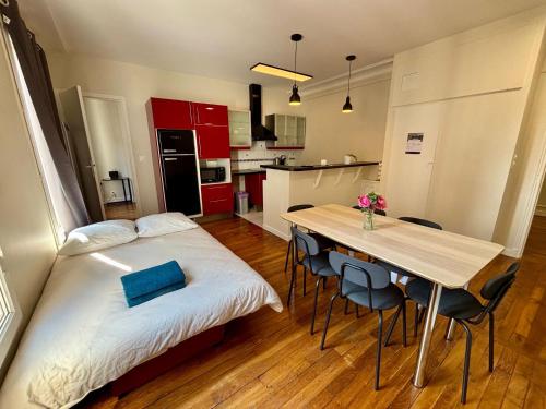 une chambre avec un lit et une table avec des chaises dans l'établissement Appartement Commerce Tour Eiffel, à Paris