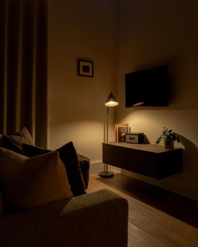 a living room with a couch and a tv at Moment Blythswood St in Glasgow