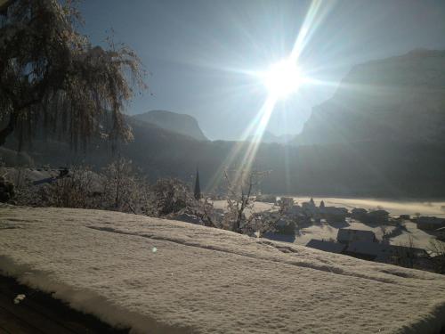 a sun is shining over a snow covered city at Apartment Marialis in Bizau