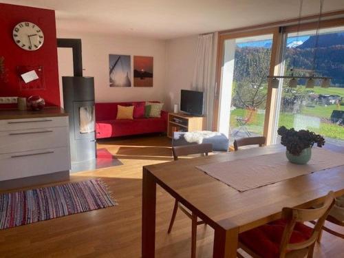 a living room with a table and a kitchen with a couch at Apartment Marialis in Bizau