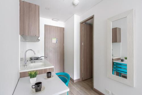 a white kitchen with a sink and a mirror at Cozy and centrally located flat near Monserrate - 11009 in Bogotá