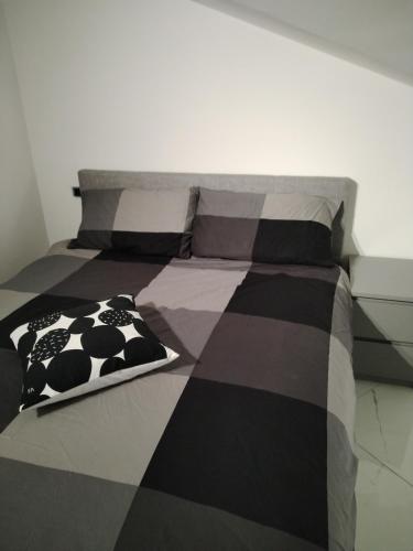 a bed with a black and white blanket on it at La casa delle Langhe in Guarene