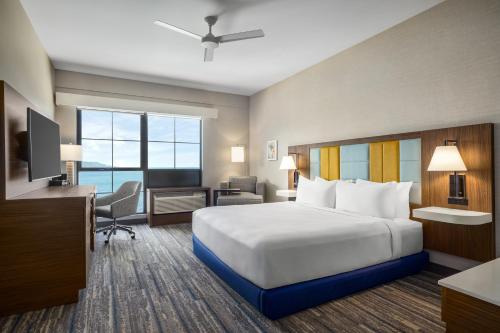 a hotel room with a large bed and a desk at Hampton Inn & Suites Maui North Shore in Kahului