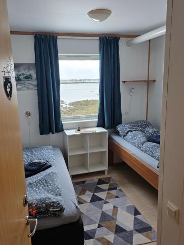 a small room with two beds and a window at Gamvik brakkebo as in Gamvik