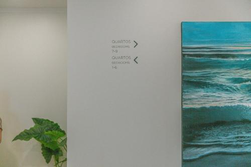 a book hanging on a wall with a picture of the ocean at Fly House Faro in FAO