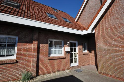 a brick house with a red roof at Nr 26 - Ferienhaus Bootsweg in Harlesiel