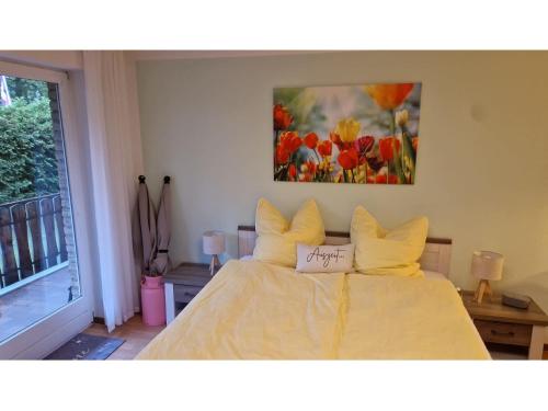 a bedroom with a bed with a painting on the wall at Auszeit Ferienwohnung in Bad Bevensen